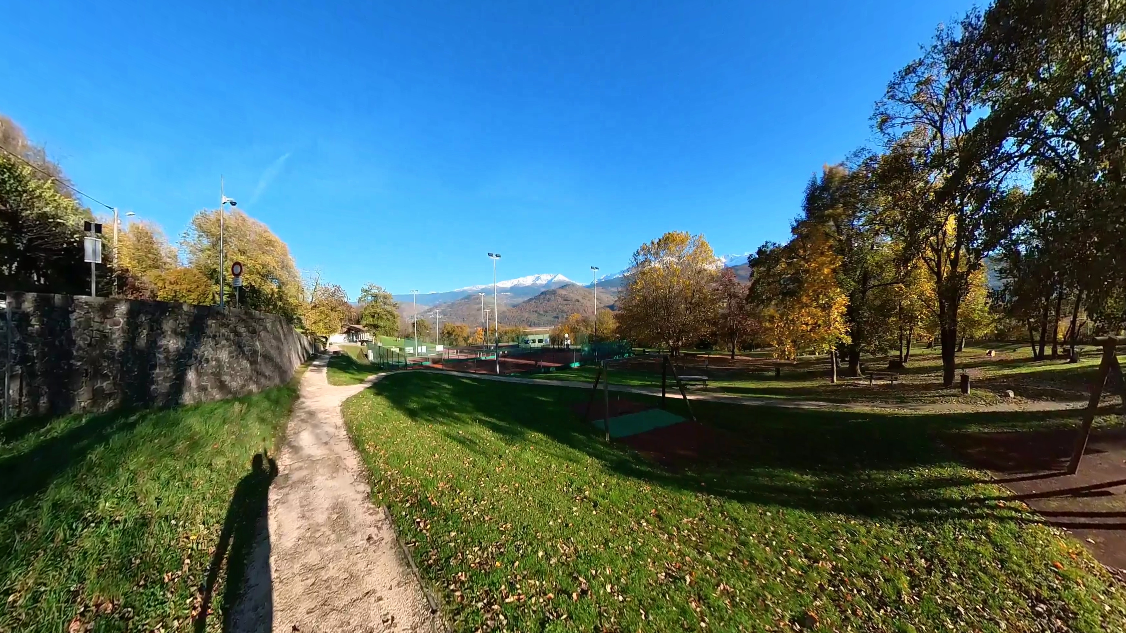 Vue du parc des Écoutoux à Saint-Nazaire-les-Eymes, montrant des courts de tennis au premier plan et des sommets montagneux en arrière-plan.

View of Parc des Écoutoux in Saint-Nazaire-les-Eymes, showing tennis courts in the foreground and mountain peaks rising behind.